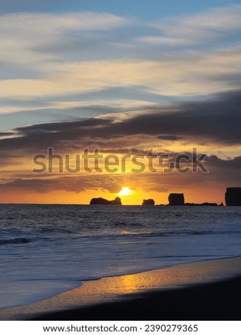 Fantastic northern scene with beachfront in iceland, ocean coastline glowing at sunset next to black sand beach. Nordic country with stunning natural views and picturesque setting.
