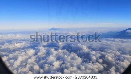 Picture of the sky taken from a window on an airplane.  with clouds and blue sky