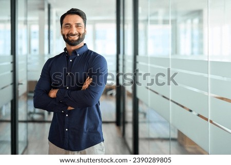 Happy Indian businessman professional leader standing arms crossed in office. Smiling male employee, business man company executive manager, confident eastern entrepreneur at work, portrait. Royalty-Free Stock Photo #2390289805