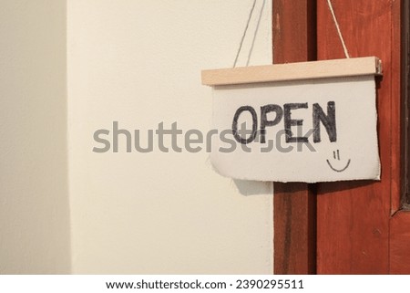 Open sign board on wooden door under morning sunlight in modern cafe coffee shop ready to service. Vintage color tone style.