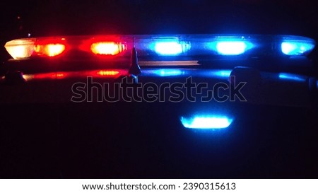 Showing a red and blue flashing light background at night. Royalty-Free Stock Photo #2390315613