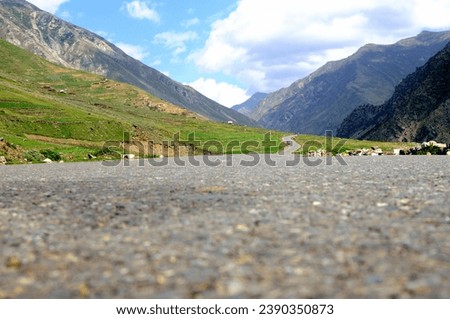 The isolation of this mountain road provides a unique experience, allowing travelers to immerse themselves in the untouched beauty of the natural landscape.  Royalty-Free Stock Photo #2390350873