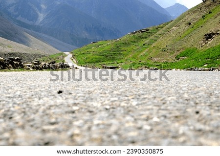 The isolation of this mountain road provides a unique experience, allowing travelers to immerse themselves in the untouched beauty of the natural landscape.  Royalty-Free Stock Photo #2390350875