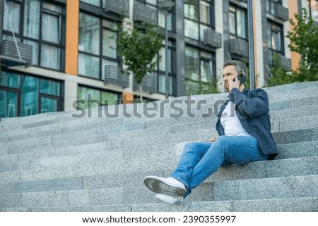 man has smartphone call outdoor, copy space. man having smartphone call in the street.