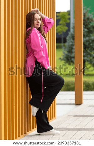 Fashionable girl near a wooden wall at home.