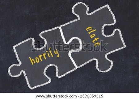 Chalk drawing of two puzzles with words horrify and elate. Concept of solving problems Royalty-Free Stock Photo #2390359315