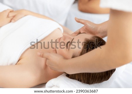 Caucasian woman enjoying relaxing anti-stress head massage and pampering facial beauty skin recreation leisure in dayspa modern light ambient at luxury resort or hotel spa salon. Quiescent Royalty-Free Stock Photo #2390363687