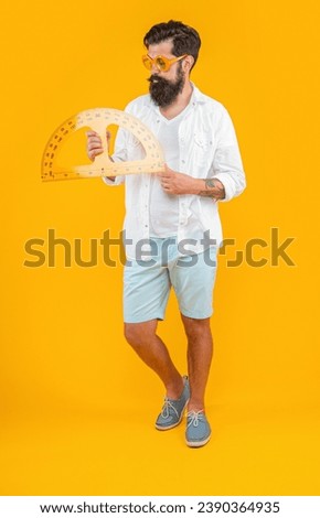 man hold geometry protractor isolated on yellow. man hold geometry protractor in studio.