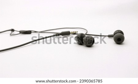 Close up of black wired earphones on white background