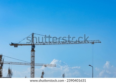 Construction industry background photo. Tower cranes in the construction site.