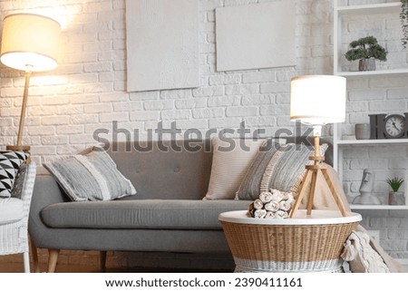 Interior of living room with cozy grey sofa and glowing lamps Royalty-Free Stock Photo #2390411161