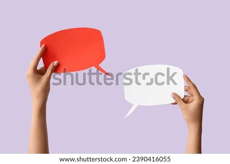 Female hands with blank speech bubbles on lilac background