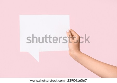 Female hand with blank speech bubble on pink background