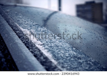 On the windshield of the car, a strip from electric heating has thawed Royalty-Free Stock Photo #2390416943
