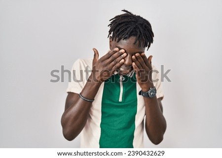 African man with dreadlocks standing over isolated background rubbing eyes for fatigue and headache, sleepy and tired expression. vision problem 