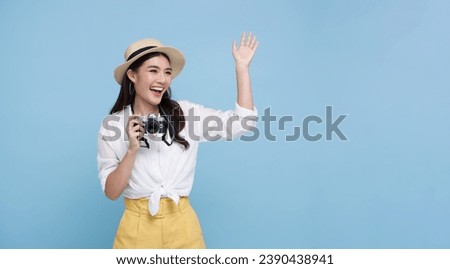Happy smiling Woman photographer is taking images photo with dslr camera isolated studio blue background.