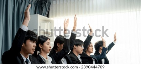 Business team or office workers raising their hands in seminar or business workshop training to ask question. Group of voluntary corporate employees volunteering with their hands up. Shrewd