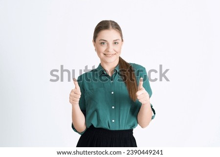 Attractive young woman shows a thumbs up gesture, a good sign, victory, success, like, isolated on a white studio background.