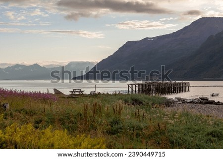 Wooden jetty on the shore of a lake with mountains in the background