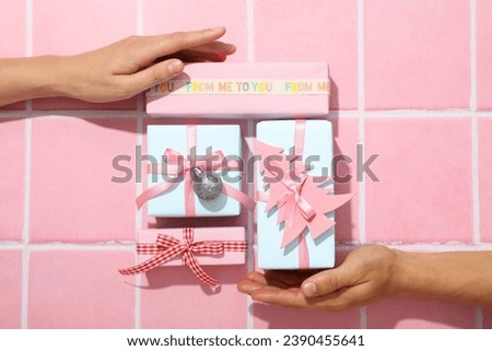Gifts with Christmas decorations on a pink background