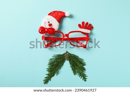 Santa's face with glasses and a sprig of needles