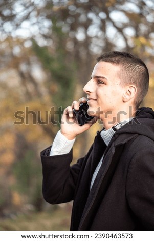 a teenage boy uses a mobile phone