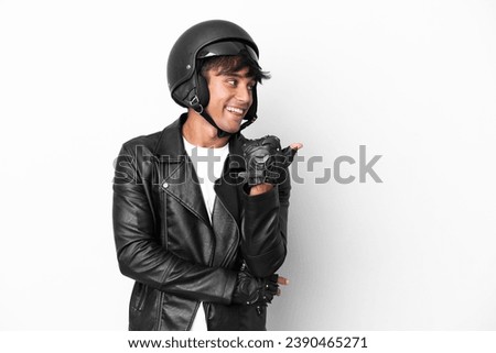 Young man with a motorcycle helmet isolated on white background pointing to the side to present a product