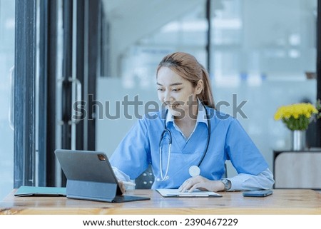 Asian female doctor with patient clipboard and tablet at hospital, Medicine and healthcare concept.