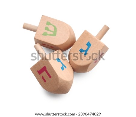 Wooden dreidels isolated on white, top view. Traditional Hanukkah game Royalty-Free Stock Photo #2390474029