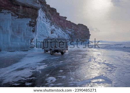 The car is on the ice of Lake Baikal near a steep cliff