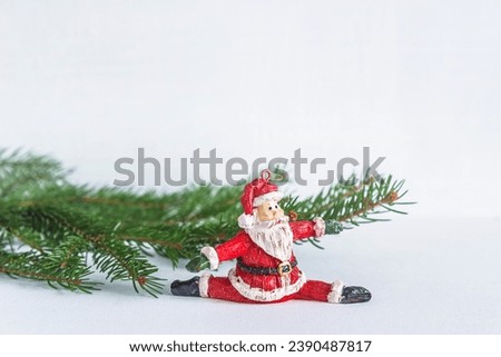 Christma holiday greeting card; Santa Claus toy and fir branches on the white background; copy space