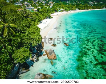 Landscape on a tropical island. Granite rocks, turquoise ocean water, tropical forest. Typical landscape on Mahe island, Seychelles. Natural landscape, vacation picture, travel banner