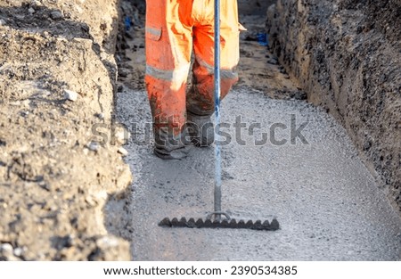Concrete cast-in-place work. Builder level wet concrete. Concrete works on buildiiing construction site Royalty-Free Stock Photo #2390534385