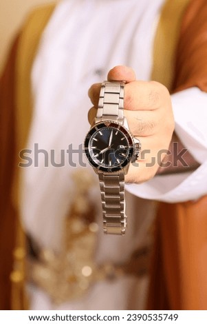 Close-up view of groom holding expensive and very beautiful watch with his left hand