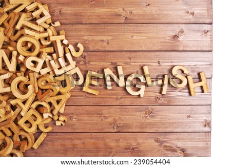 Word english made with block wooden letters next to a pile of other letters over the wooden board surface composition Royalty-Free Stock Photo #239054404