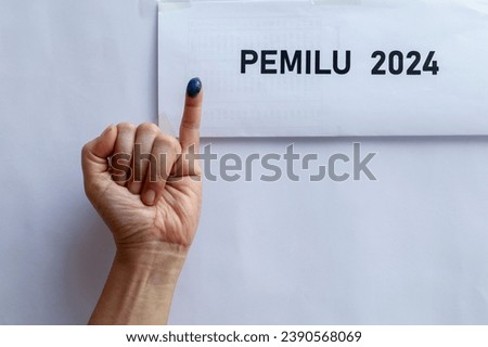 Indonesian election 2024. little finger with ink as a sign of voting rights, presidential election on the Indonesian election box. Royalty-Free Stock Photo #2390568069
