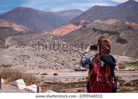 Tourist taking photos of the beautiful mountains in Tilcara, Jujuy, Argentina. Vacation person taking photos. Beautiful landscape of northern Argentina Royalty-Free Stock Photo #2390568513