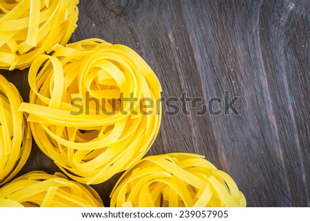 Raw pasta on wooden background - process old dark style picture