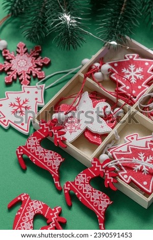 Christmas box with eco friendly wooden toys and fir tree branches on a green background.
