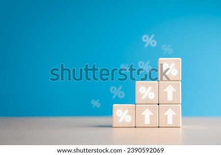 Staked wooden cube blocks with percentage symbol and arrow up icons. Interest rate financial rise and mortgage rates hike concept. Loan mortgage, VAT, inflation, sale price, and tax increase.