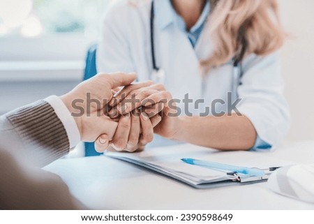 Cropped close up of female doctor holding her patient hand supporting. Support hope concept. Telling diagnosis. Assisting elderly patient. Caregiver. Trust in hospital clinic Royalty-Free Stock Photo #2390598649