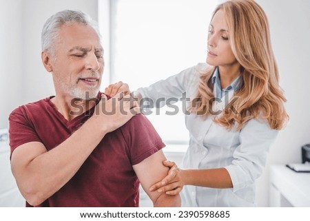 Traumatology, orthopedist concept. Medical examination on patient shoulder in clinic. Injury and dislocations. Reflexology and physiotherapy for elderly people Royalty-Free Stock Photo #2390598685