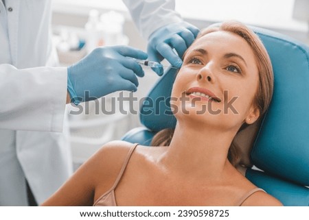 Beautiful middle aged woman get injection in clinic. Cosmetology and beauty concept. Anti-age anti-wrinkle shots with botox botulinum, facial serum for lifting effect. Royalty-Free Stock Photo #2390598725