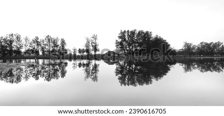 Beautiful reflections of house at Lake in the early morning mist, in black and white. panoramic image.