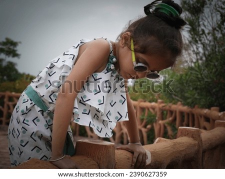 Ai photo filter effect on little girl sitting in wood platform.Wearing white and making comedy action.