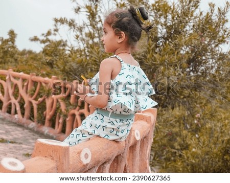 Ai photo filter effect on little girl sitting in wood platform.Wearing white and making comedy action.