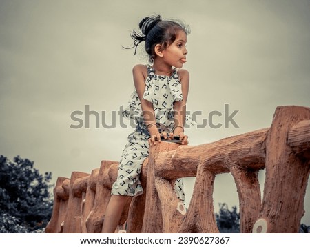 Ai photo filter effect on little girl sitting in wood platform.Wearing white and making comedy action.