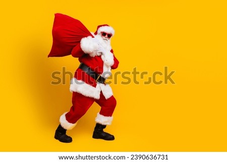 Side photo of pensioner man steps santa claus sack wearing red costume overweight person celebrate xmas isolated on yellow color background