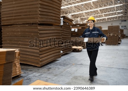Caucasian businesswoman holding kraft paper pack and checking Kraft paper stock in warehouse	