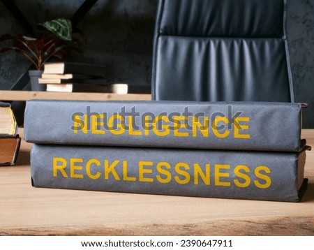 Law books about negligence and recklessness on the desk. Royalty-Free Stock Photo #2390647911